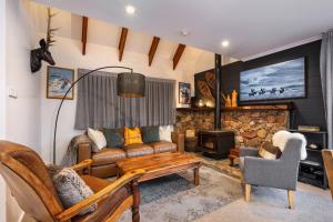 a living room with a couch and a tv at Crackenback Castle Chalet in Thredbo