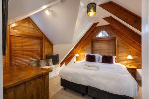 a bedroom with a large white bed and a desk at Crackenback Castle Chalet in Thredbo