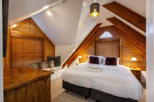 a bedroom with a large white bed and a desk at Crackenback Castle free standing chalet with fire place in Thredbo