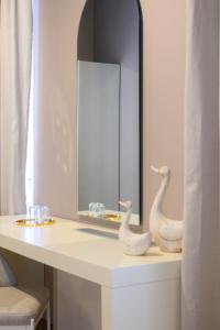 a bathroom with a mirror and two white swans on a counter at BlueBlood - The Rooms in Kalamata