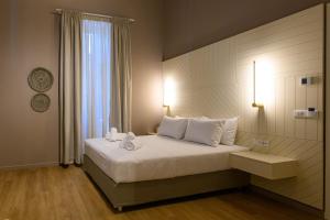 a bedroom with a large white bed with a window at BlueBlood - The Rooms in Kalamata