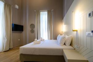 sypialnia z dużym białym łóżkiem i oknem w obiekcie BlueBlood - The Rooms w Kalamácie