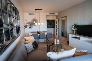 een woonkamer met een bank en een eetkamer bij Luxury apartment with panoramic views - Marbella in Estepona