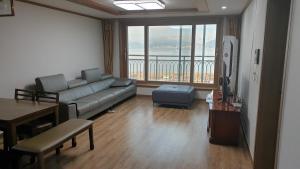 a living room with a couch and a large window at Geoje Seaside Two floors Villa in Geoje 
