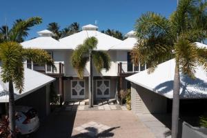 a house with palm trees in front of it at 2/24 Donkin - Luxury - Absolute Beachfront in Mission Beach