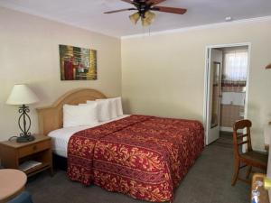 a hotel room with a bed and a ceiling fan at Rolling Brook Inn in Maggie Valley