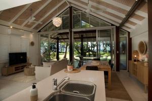 a kitchen with a sink and a living room at Nikatara - Mission Beach - 3 Bedroom Town House in Mission Beach