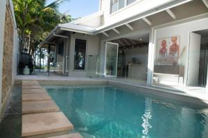 a swimming pool in front of a house at Nikatara - Mission Beach - 3 Bedroom Town House in Mission Beach