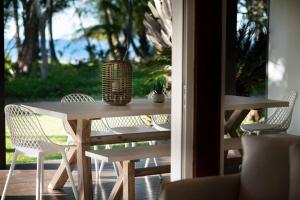 une table et des chaises avec un vase sur une terrasse couverte dans l'établissement Nikatara - Mission Beach - 3 Bedroom Town House, à Mission Beach