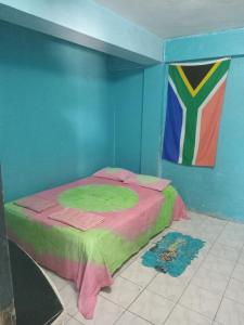 a small bed in a room with a painting on the wall at Save's Homestay in Nadi