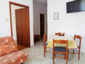 a dining room with a table and chairs and a television at Apartments with parking space Moscenicka Draga, Opatija - 2327 in Mošćenička Draga