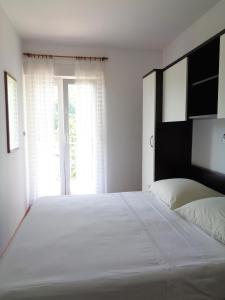 een slaapkamer met een groot wit bed en een raam bij Apartment Moscenicka Draga 2327c in Mošćenička Draga