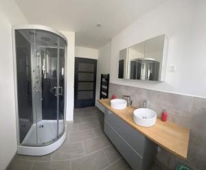 a bathroom with a shower and two sinks in it at Cocon lumineux près des pistes in La Bresse