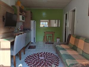 a living room with a couch and a kitchen at Fazendinha Adoro in Farroupilha