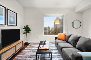 a living room with a couch and a flat screen tv at Kasa Lady Bird Lake Austin in Austin