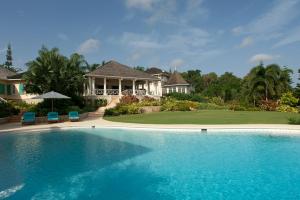 a large swimming pool in front of a house at Sunny Vacation Villa No 5 in Montego Bay