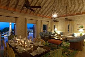 a dining room with tables and chairs and a living room at Sunny Vacation Villa No 5 in Montego Bay