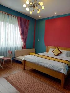 een slaapkamer met een bed en een rode muur bij Bich Ngoan HOTEL in Trà Vinh