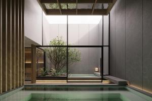 a pool in a house with a glass wall at Nozo Hotel in Furano