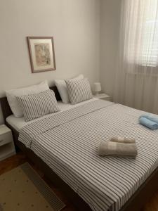 a bedroom with a large bed with a towel on it at Apartments Toni-Malinska in Malinska