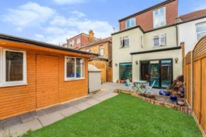 a backyard of a house with a lawn at Large, light & airy 4 bedroom home on quiet road in London