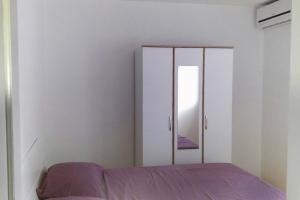 a bedroom with a bed and a mirror at Family friendly apartments with a swimming pool Kneza, Korcula - 9130 in Račišće