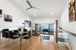 a dining room and living room with a table and chairs at Shorelines 27 Ocean View Buggy Transfers BBQ in Hamilton Island