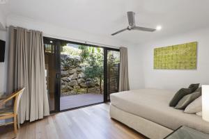 a bedroom with a bed and a sliding glass door at Shorelines 27 Ocean View Buggy Transfers BBQ in Hamilton Island