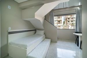 - un escalier blanc dans une chambre avec fenêtre dans l'établissement Flórida Premium, à Bombinhas