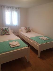 2 Betten in einem Zimmer mit Handtüchern darauf in der Unterkunft Holiday house with a parking space Milna, Brac - 20140 in Milna
