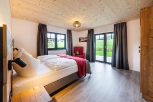 a bedroom with a bed in a room with windows at Ferienhaus Froschsee in Ruhpolding