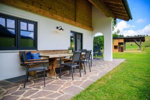 a patio with a wooden table and chairs at Ferienhaus Froschsee in Ruhpolding