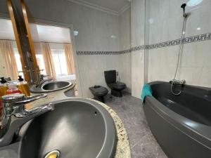 ロス・アルカサレスにあるBelvilla by OYO Holiday home in Los Alcazaresのバスルーム(洗面台2台、バスタブ、トイレ付) +21枚の写真