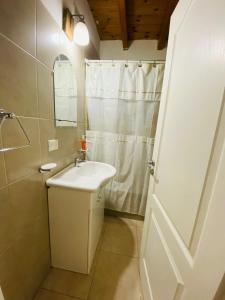 a white bathroom with a sink and a shower at La alegre! Hermosa casa centrica y cerca del mar in Puerto Madryn