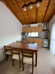 a large kitchen with a wooden table and chairs at La alegre! Hermosa casa centrica y cerca del mar in Puerto Madryn