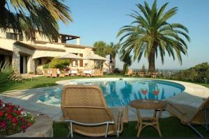 una piscina con sillas, una mesa y una casa en Le Haut des Espinets, en Saint-Paul-de-Vence