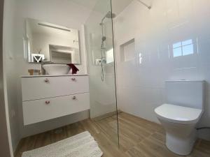 a bathroom with a toilet and a glass shower at Casa Pirilampo Ferragudo in Ferragudo
