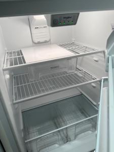 an empty refrigerator with its door open and its shelves at Beautiful 1-bedroom Townhome with nice amenities in Houston