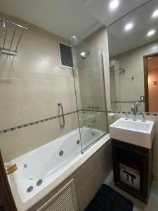 a bathroom with a tub and a sink and a mirror at Andino Apartaments Rental Capital in San Juan +17 photos