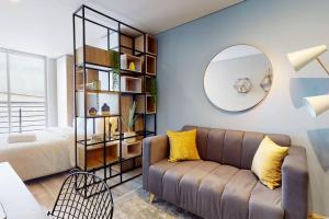 a living room with a couch and a mirror at Horizon 85 Lofts Zona T in Bogotá