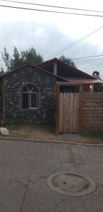 a brick house with a wooden gate and a door at Cabaña Los Ángeles in Huasca de Ocampo +4 photos