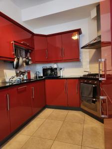 a red kitchen with red cabinets and appliances at Our Tiny Little Home in Cork