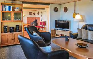 sala de estar con sillas negras y mesa en Beautiful Home In Aakirkeby With Kitchen, en Spidsegård