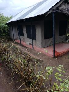 a tent with a red floor and a metal roof at Mara Forest camp in Keekorok