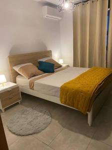 ein Schlafzimmer mit einem großen Bett und einer gelben Decke in der Unterkunft Le petit colibri in Rémire-Camp