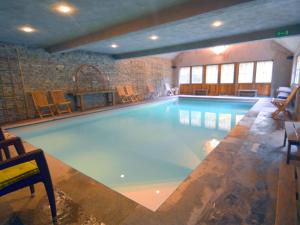 uma grande piscina num grande quarto com cadeiras em Magnificent Manor in Vresse-Sur-Semois with Sauna em Vresse-sur-Semois