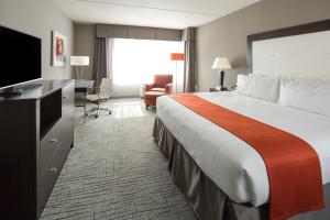 a hotel room with a large bed and a television at Holiday Inn Hotel & Suites Davenport, an IHG Hotel in Davenport