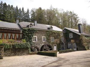 um grande edifício de pedra com hera crescendo sobre ele em Magnificent Manor in Vresse-Sur-Semois with Sauna em Vresse-sur-Semois