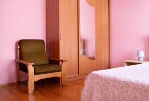 una silla verde sentada en una habitación junto a una cama en Апартаменти на Сихові, Драгана 1й en Leópolis