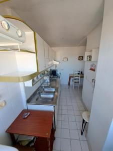 uma pequena cozinha com um lavatório e uma mesa em Galería Entre Ríos em Concordia